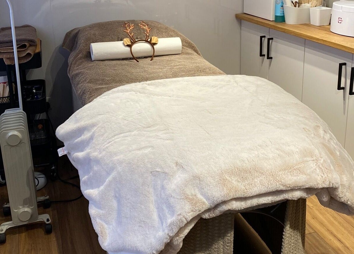 Relaxing treatment room with massage bed at The Beauty Cabin, Swadlincote, England, GB.