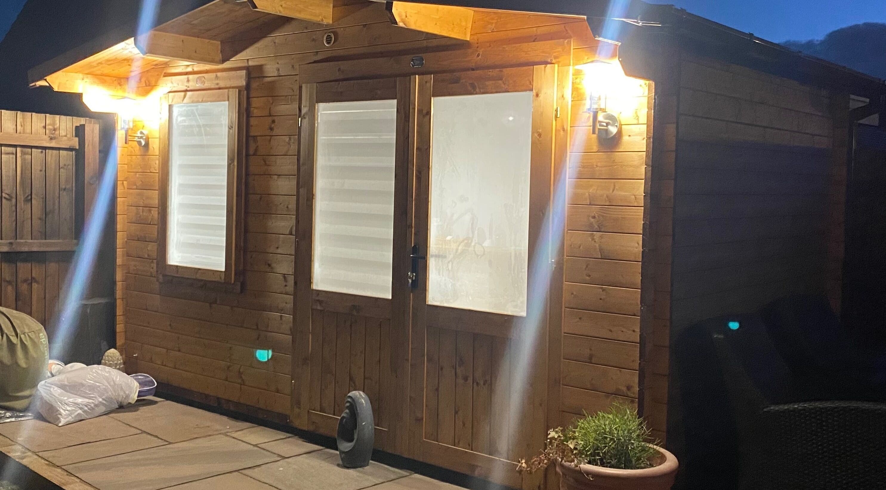 Exterior of The Beauty Cabin lit warmly at night, located in Swadlincote, England, GB.