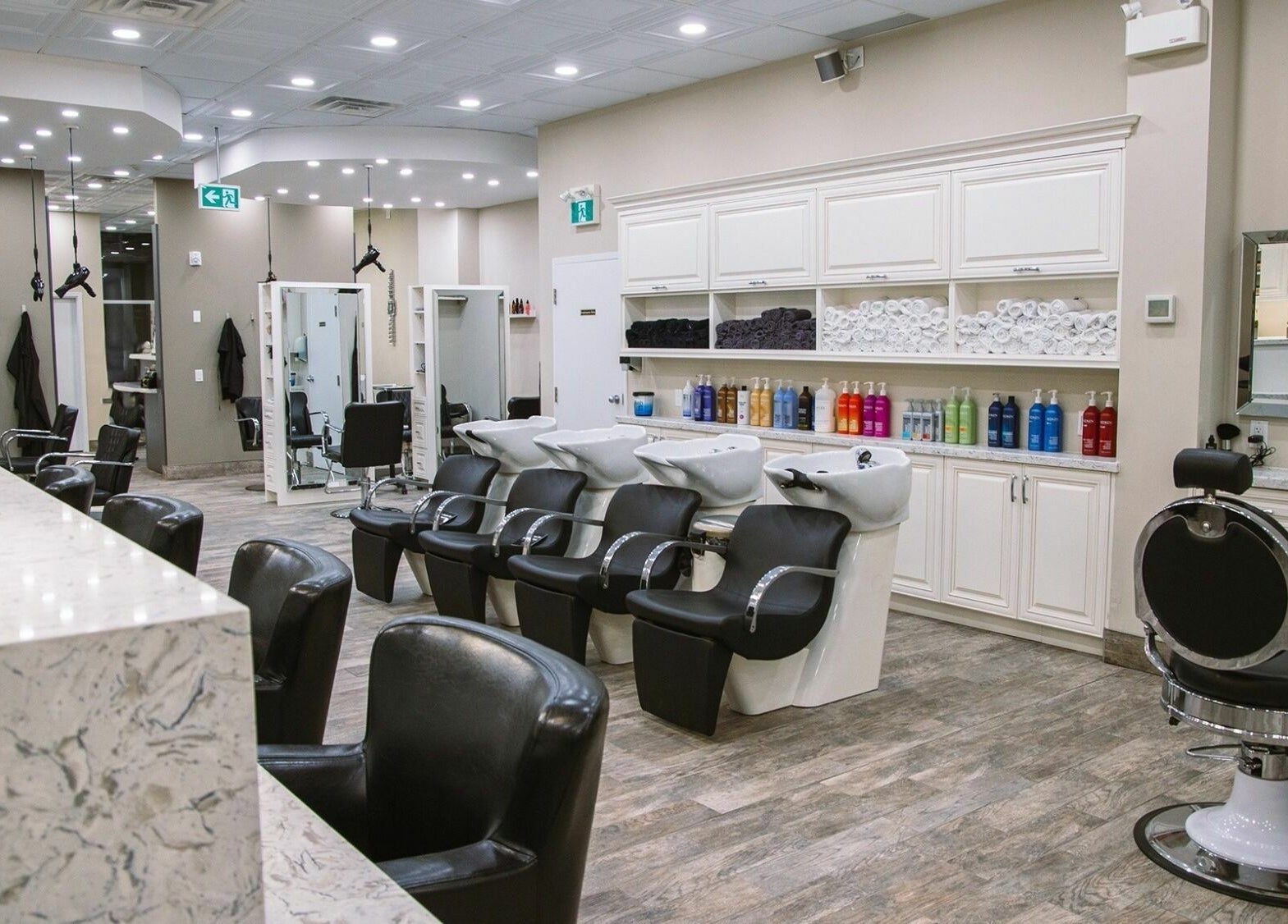Foiled Salon and Spa in Cambridge, Ontario, CA features modern stylist chairs and sleek washing stations.