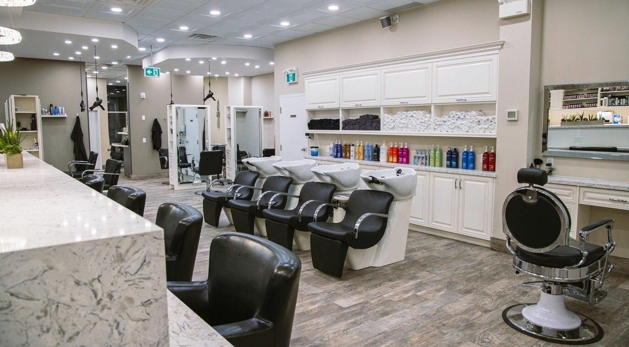 Foiled Salon and Spa in Cambridge, Ontario, CA features modern stylist chairs and sleek washing stations.