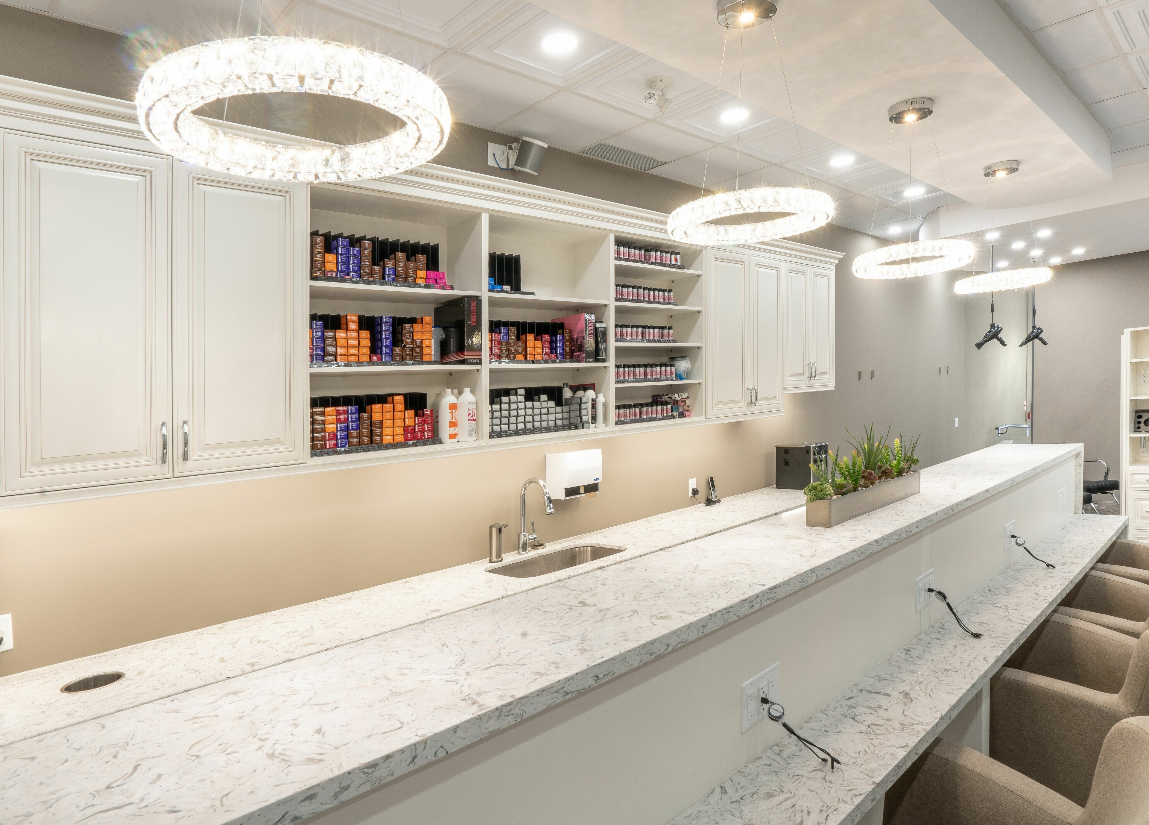 Bright, modern interior of Foiled Salon and Spa in Cambridge, Ontario, CA featuring stylish countertops and seats.