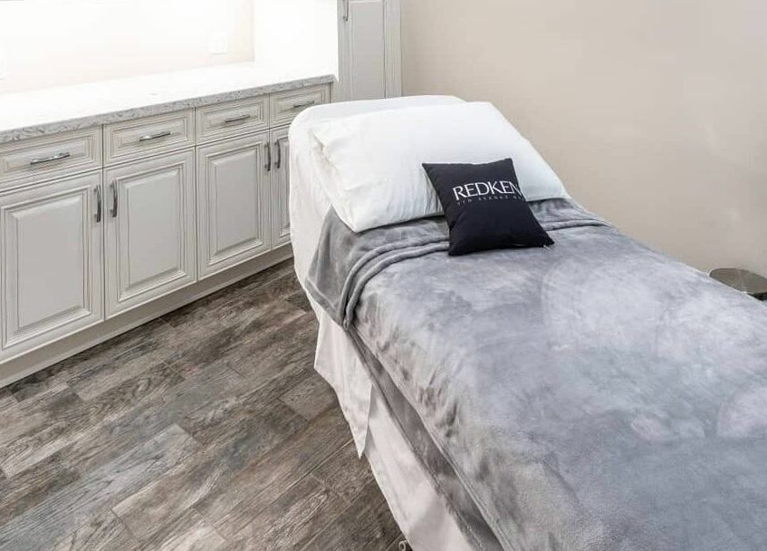 Cozy massage room at Foiled Salon and Spa, Cambridge, Ontario, CA with soft blankets and modern decor.