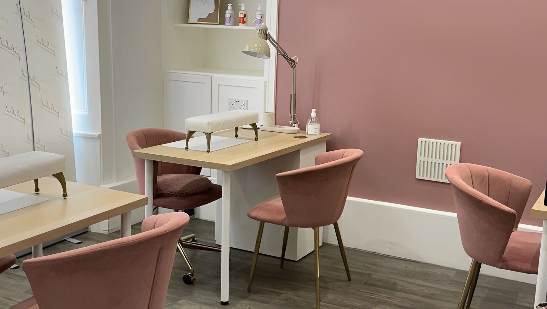 Elegant nail care area at Totally Polished Tadcaster, Tadcaster, England, GB with pink chairs and manicure tables.
