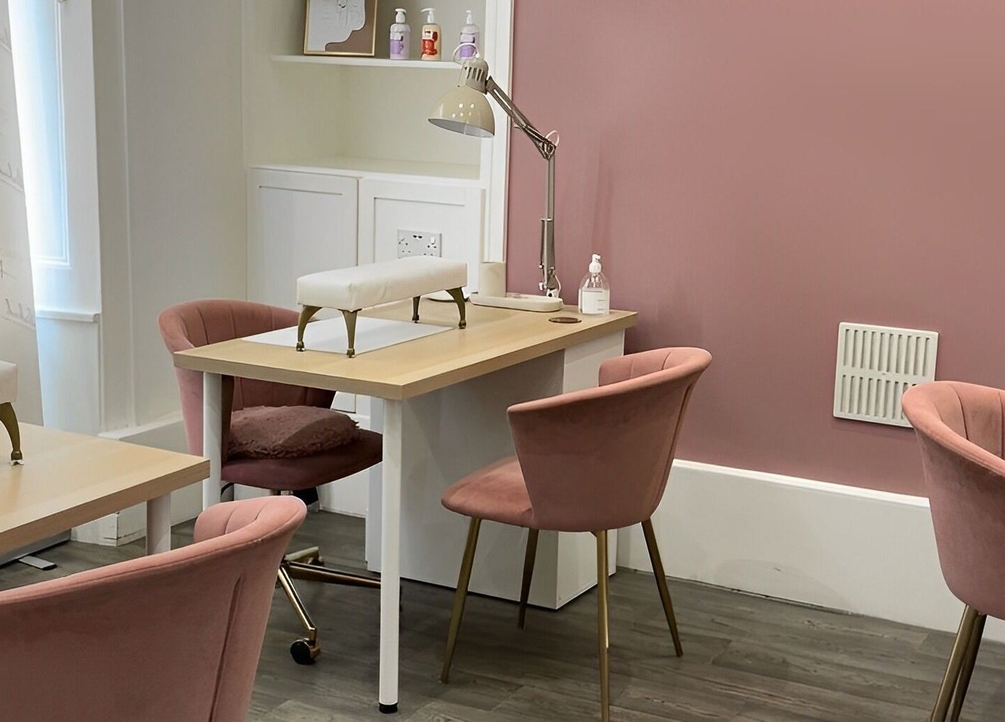 Elegant nail care area at Totally Polished Tadcaster, Tadcaster, England, GB with pink chairs and manicure tables.