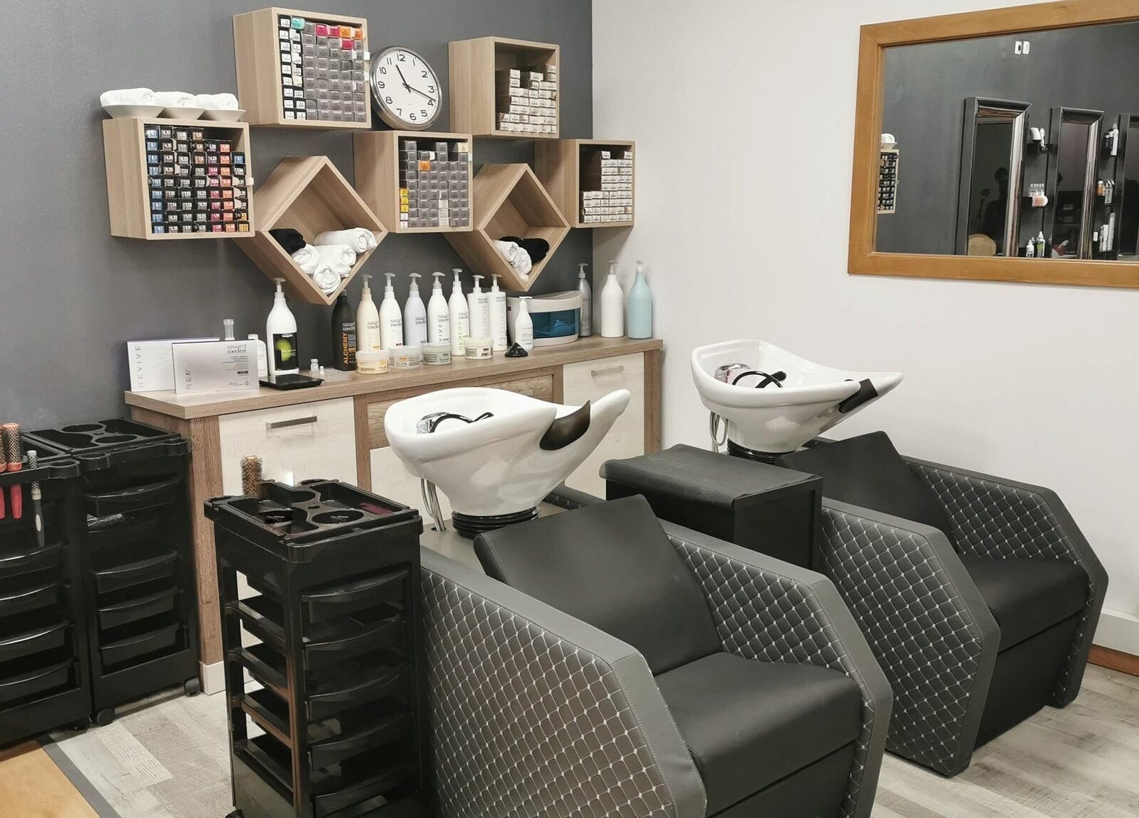 Área de lavagem elegante no Michele Encke - Queijas em Oeiras, Lisboa, PT, com cadeiras e prateleiras organizadas.