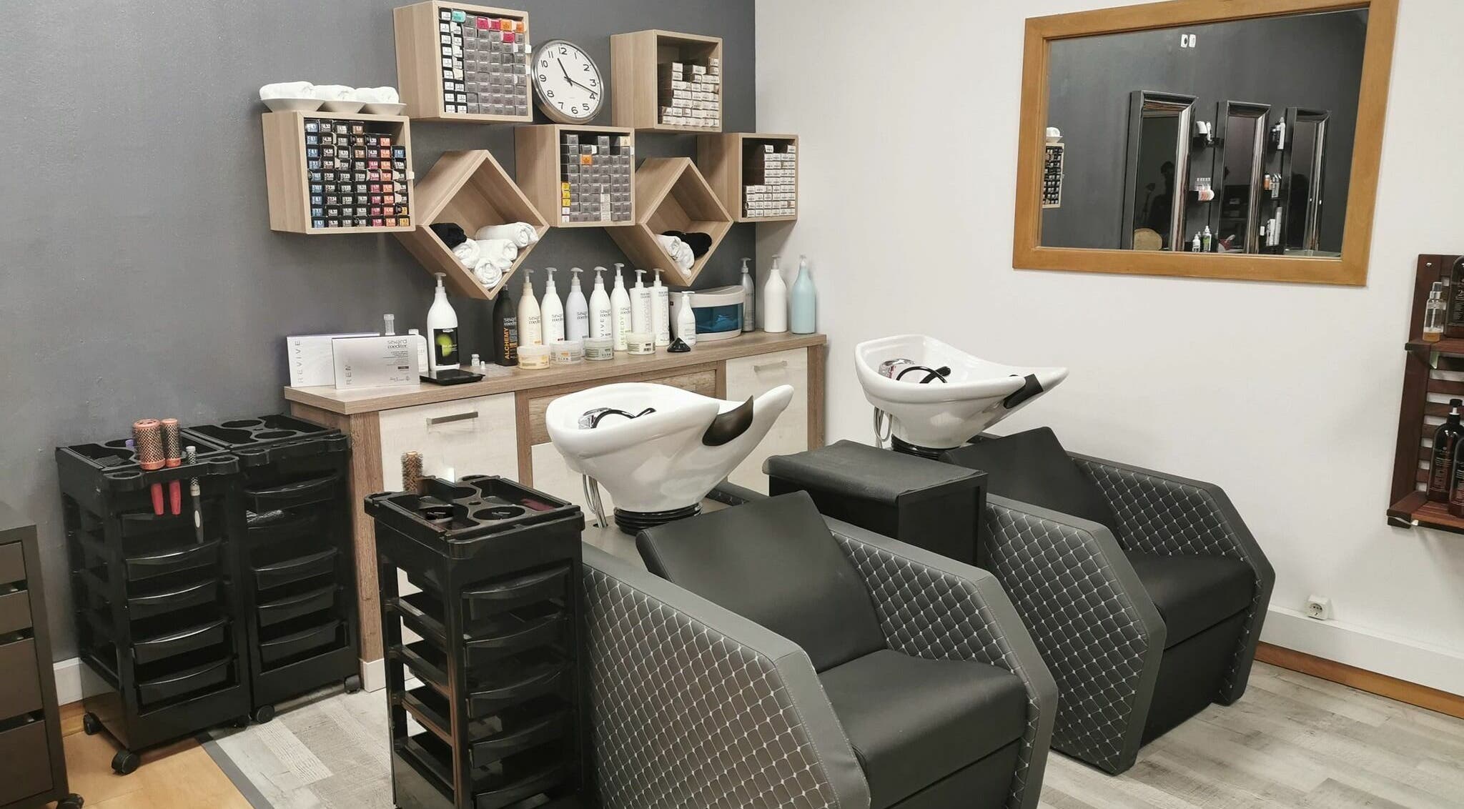 Área de lavagem elegante no Michele Encke - Queijas em Oeiras, Lisboa, PT, com cadeiras e prateleiras organizadas.