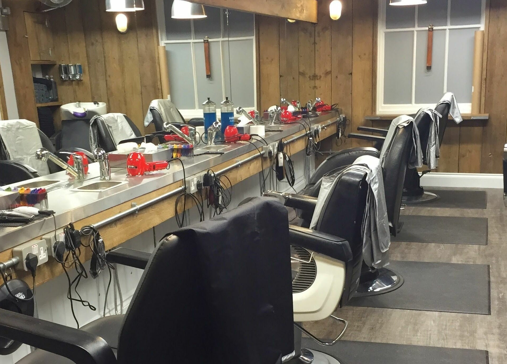 Interior of Chapps Barbershop in Southwold, England, showing classic barber chairs and grooming tools.