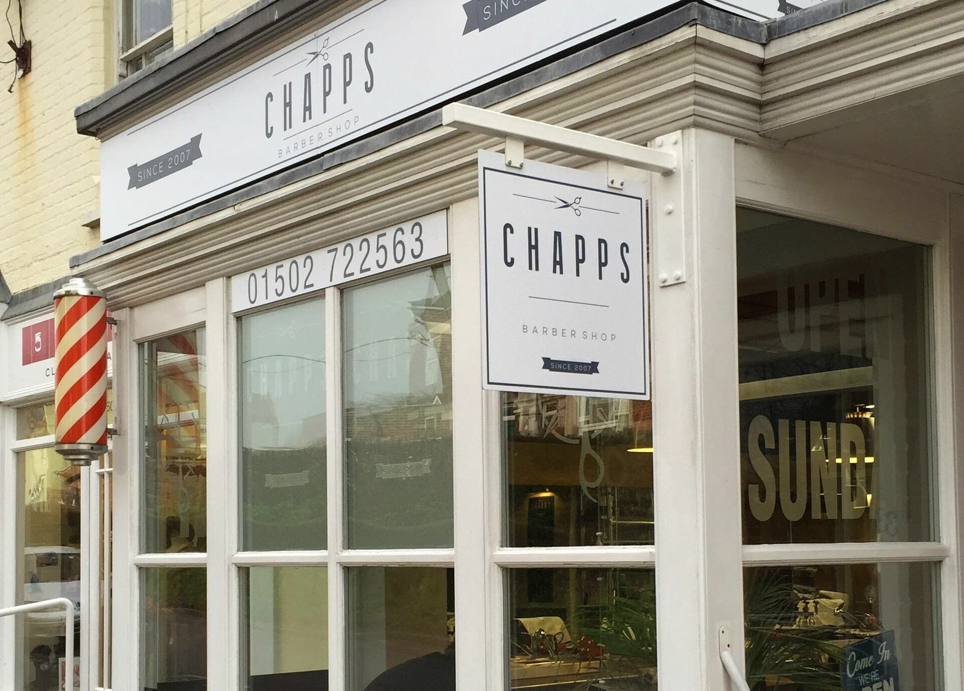 Exterior view of Chapps Barbershop in Southwold, England, GB, showcasing its iconic barber pole.