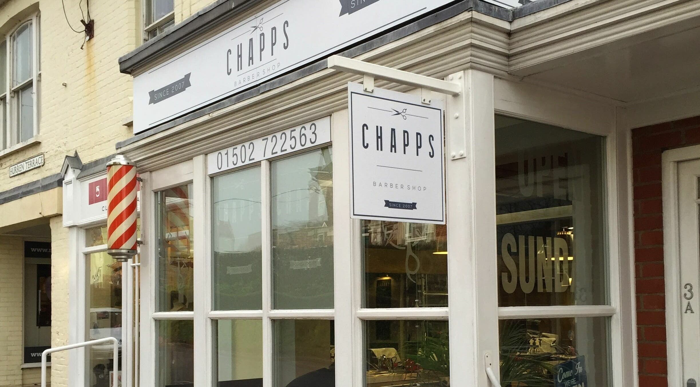 Exterior view of Chapps Barbershop in Southwold, England, GB, showcasing its iconic barber pole.