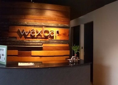 Reception area of Waxbar Teachers Village, Quezon City, PH, with a wooden wall and sleek counter.