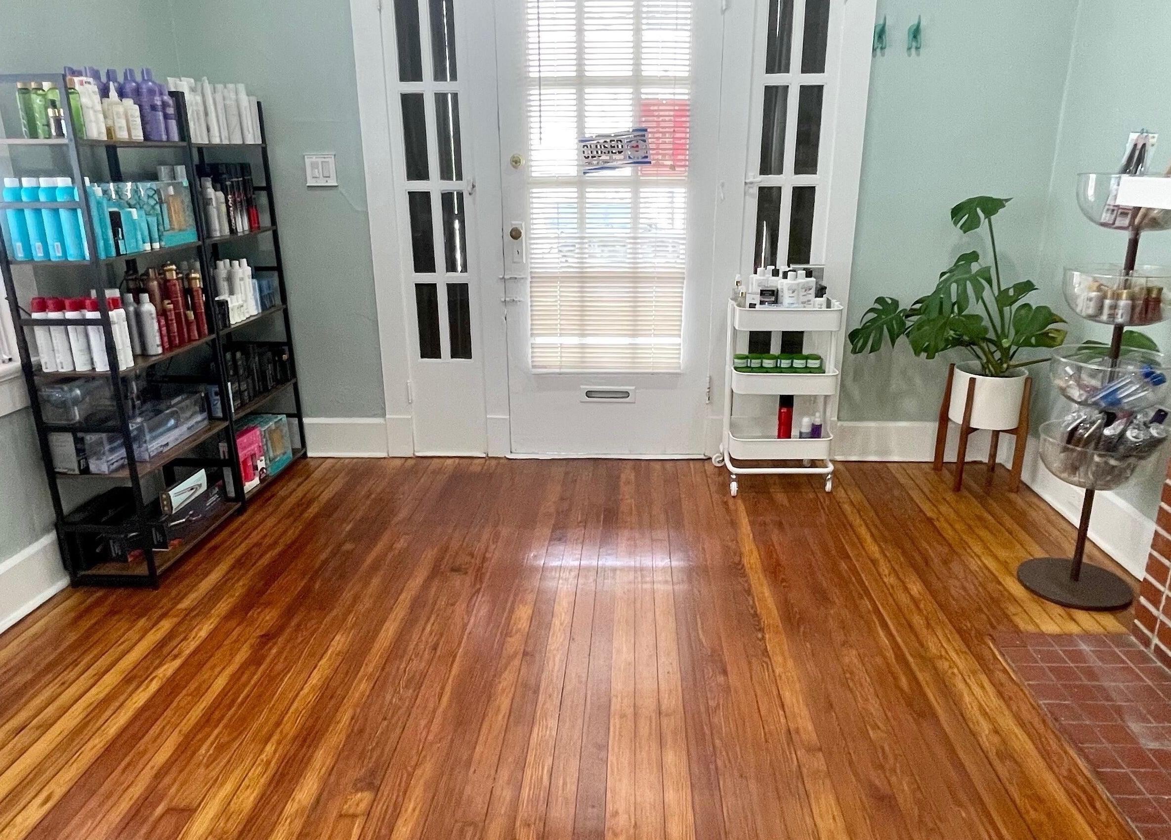 Elegant salon interior at The Xperience Cut, New Orleans, Louisiana, US, featuring wooden floors and product shelves.