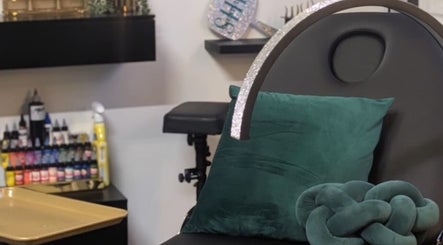 Cozy beauty chair at She Studios, London, Ontario, CA, featuring green cushions and neatly arranged products.