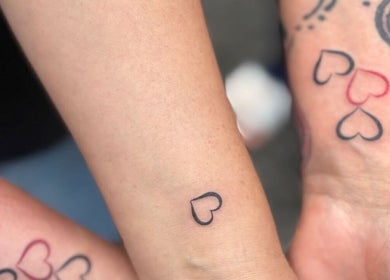 Matching heart tattoos on arms at She Studios, London, Ontario, CA. Artistic expression and personalization.