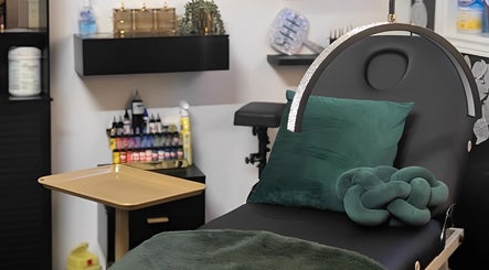 Calm treatment area at She Studios, London, Ontario, CA, featuring stylish green decor and beauty essentials.