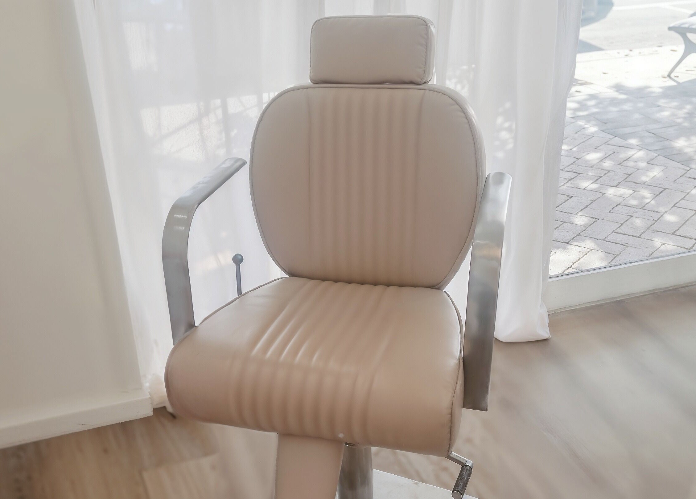 Comfortable salon chair at Blush Aesthetics, Avoca Beach, New South Wales, AU, near sunlit window.