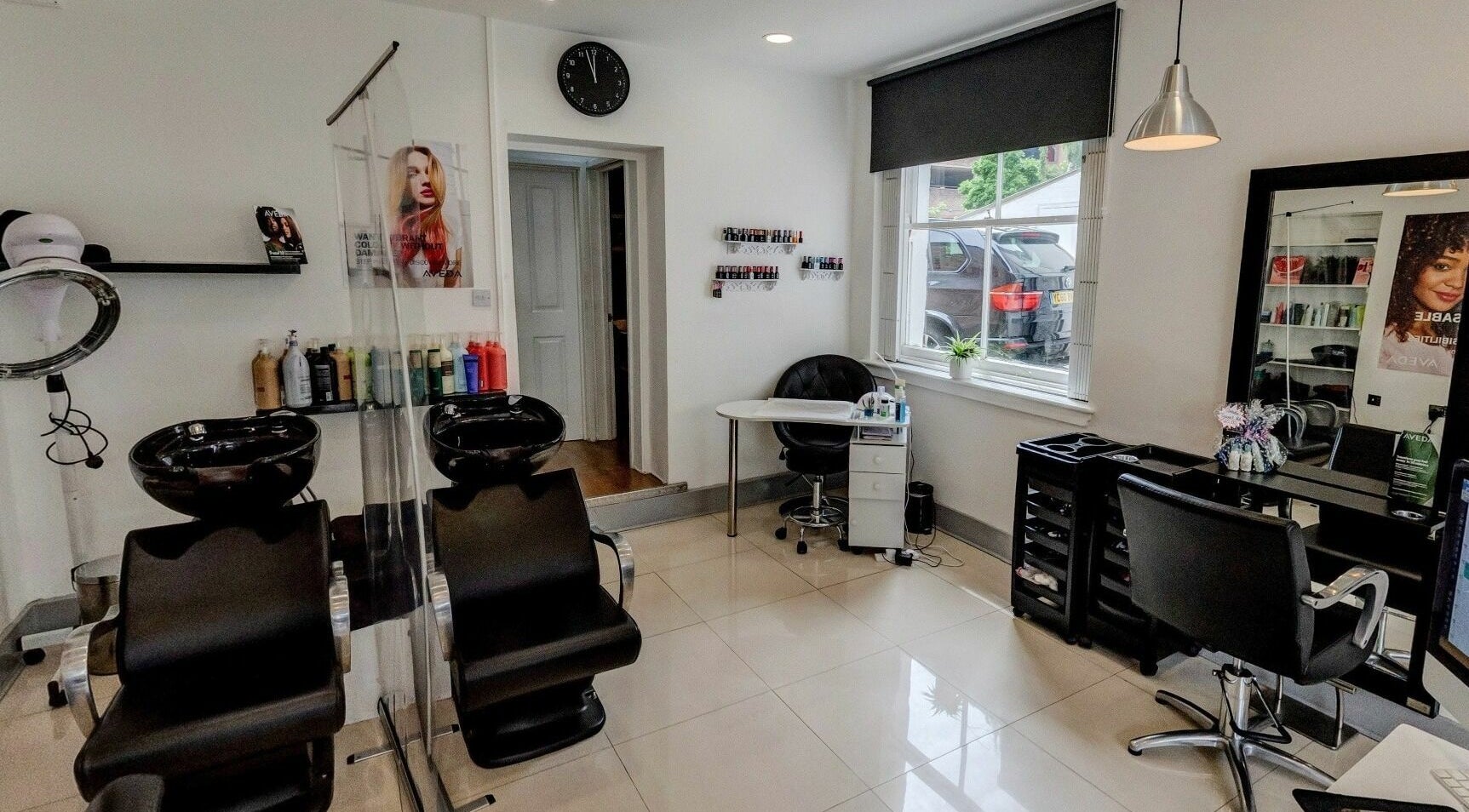 Modern interior of Fatima Hair Boutique in Epsom, England, GB with sleek black chairs and hair stations.