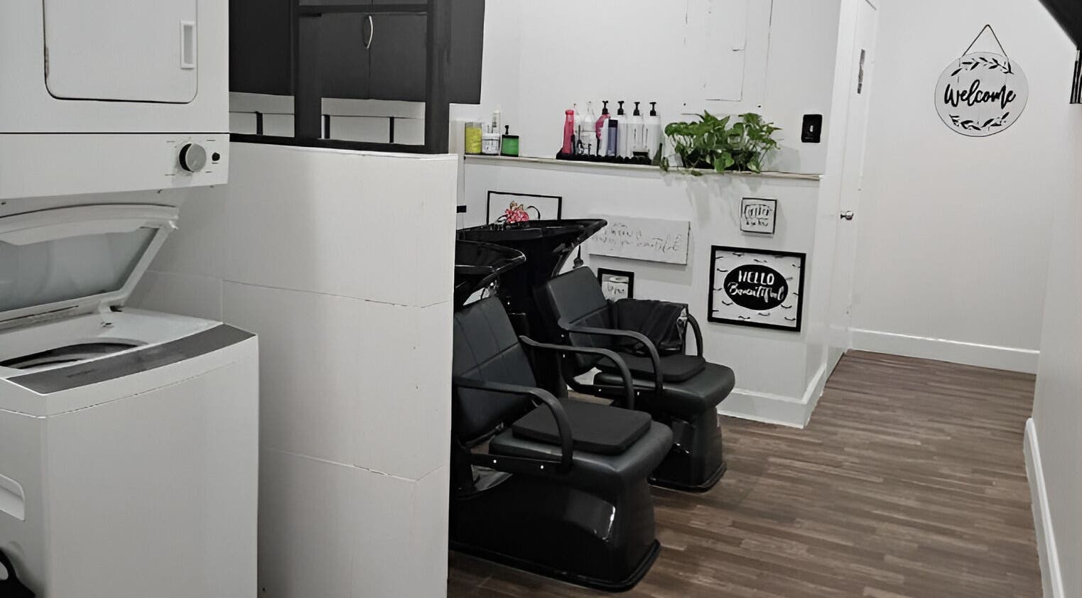 Shampoo area at The Hair and Makeup Bar, Davie, Florida, US showcasing sleek black chairs and decor.