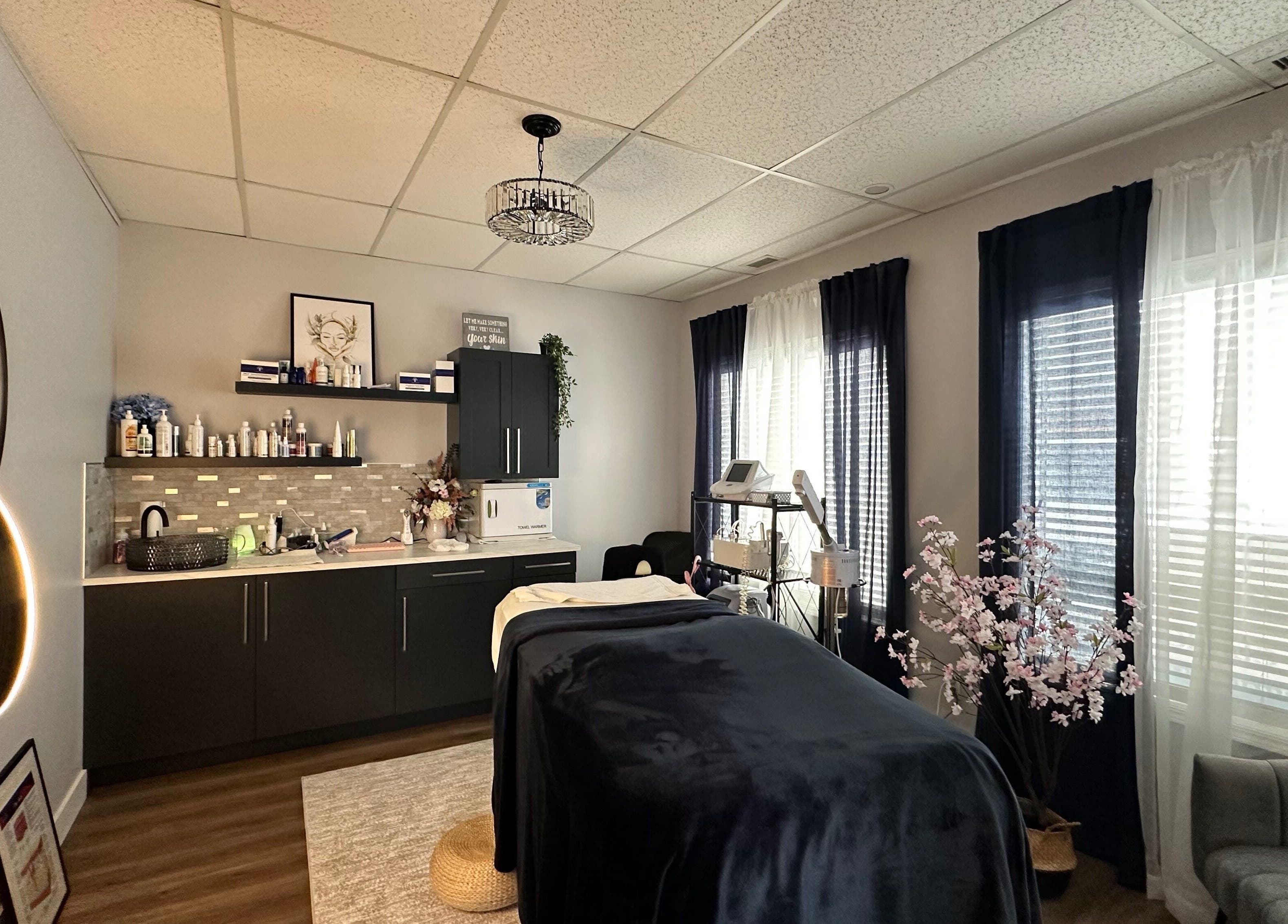 Relaxing treatment room at Radiate Skin Wellness in Whitecourt, Alberta, CA with elegant decor and spa bed.