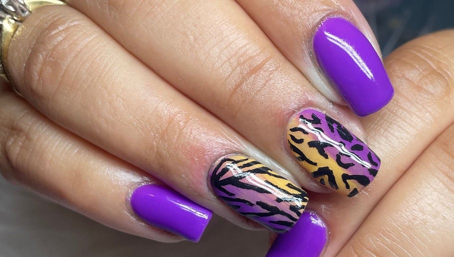 Vibrant nail art featuring purple polish and leopard design by Beauty by Eme - Mobile Nails & Beauty Birmingham.