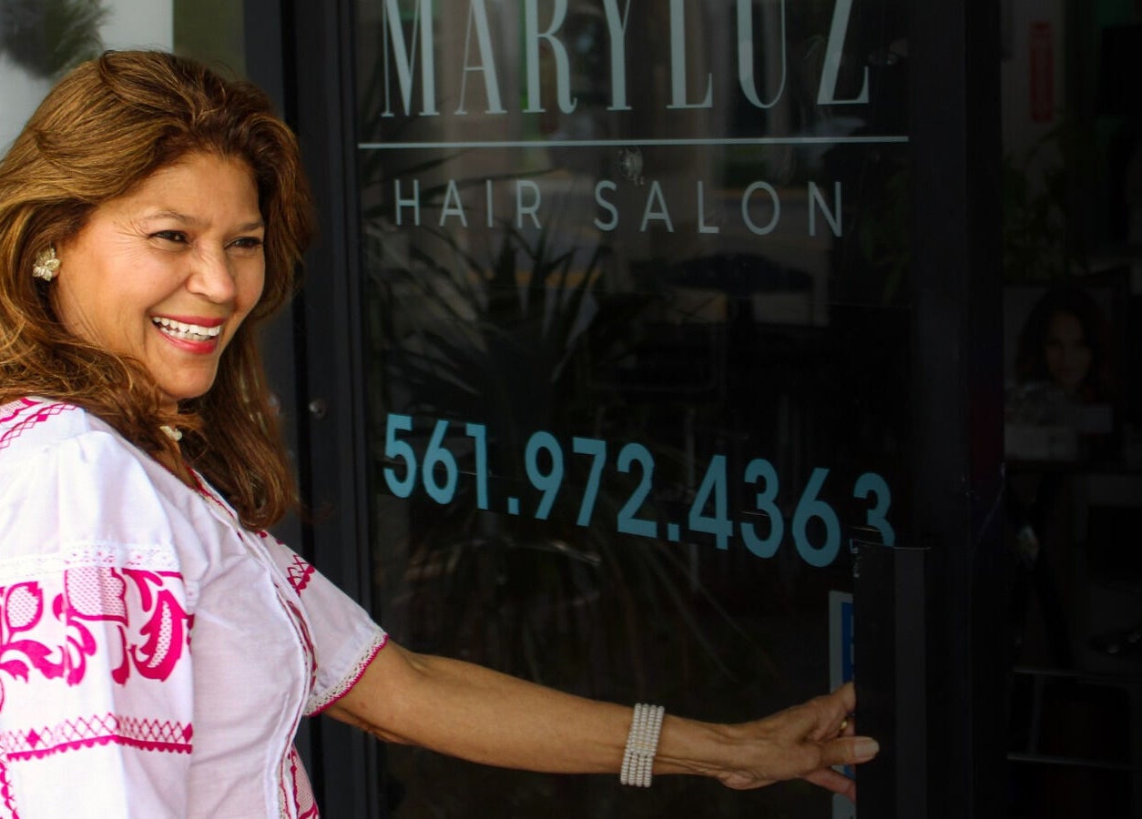 Smiling woman entering MaryLuz Hair Salon in Jupiter, Florida, US.