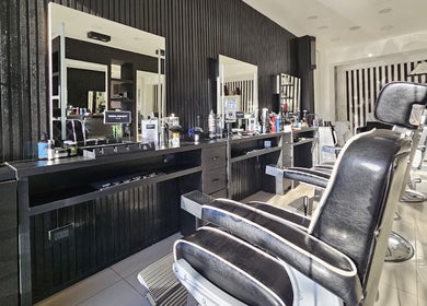 Interior del salón Hugo Amadey en Villa Carlos Paz, Córdoba, AR con sillas de barbero y espejos sofisticados.