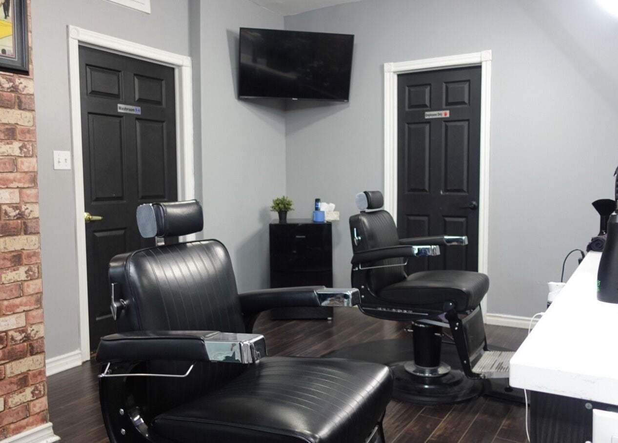 Interior of One Touch Barbers Inc in Markham, Ontario featuring sleek barber chairs and rustic brick wall decor.