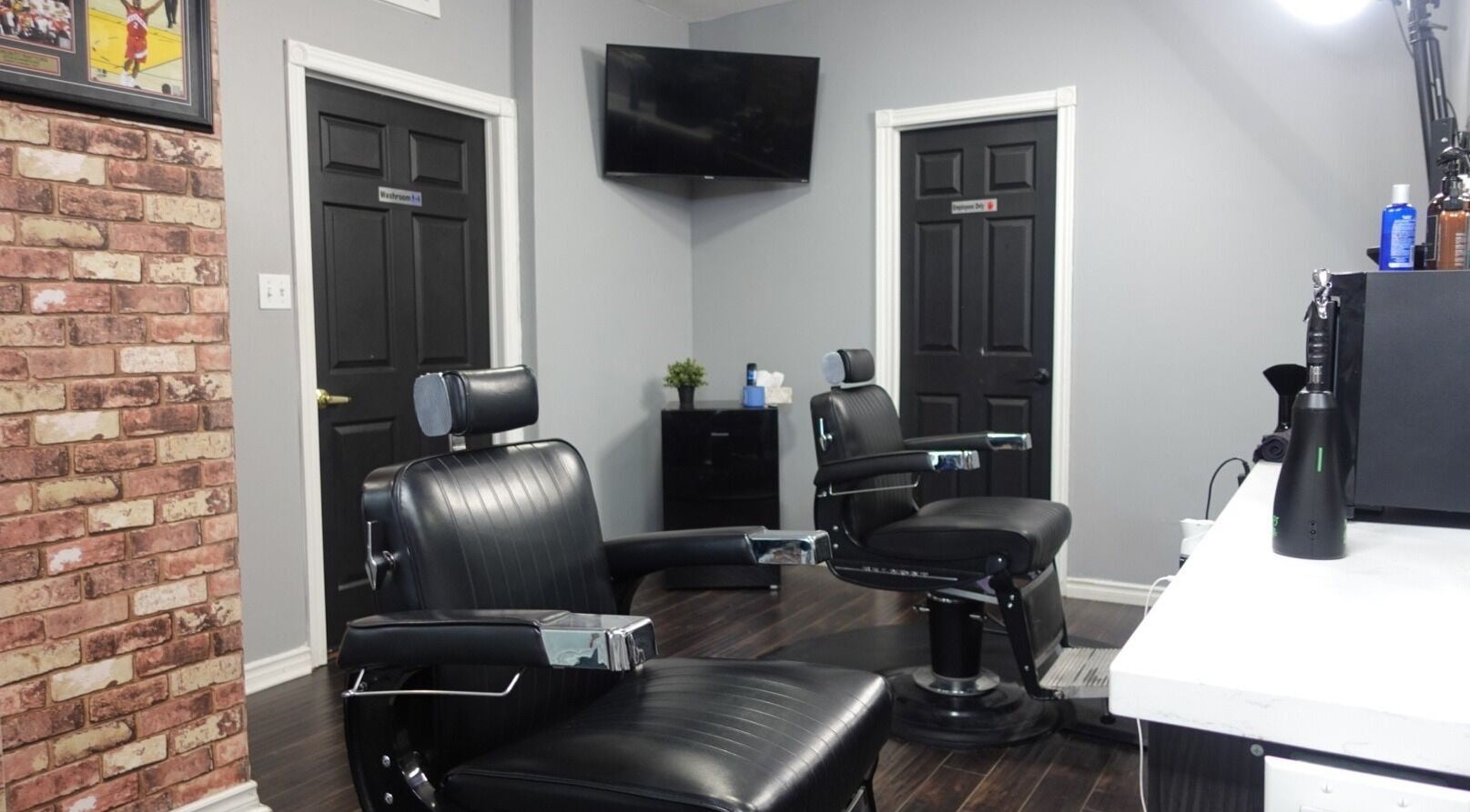 Interior of One Touch Barbers Inc in Markham, Ontario featuring sleek barber chairs and rustic brick wall decor.