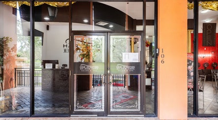 Entrance of Hair in Motion of New York - MetroWest in Orlando, Florida, US with glass doors and vibrant decor.