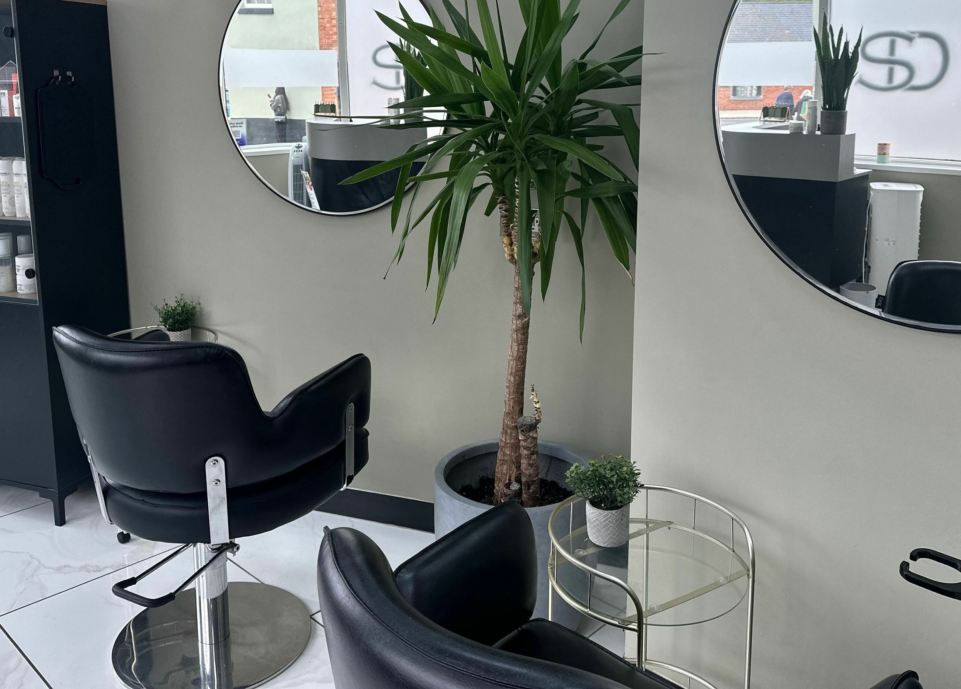 Sophisticated styling area at Shear Desire, Shepshed, England, GB featuring modern chairs and large mirrors.