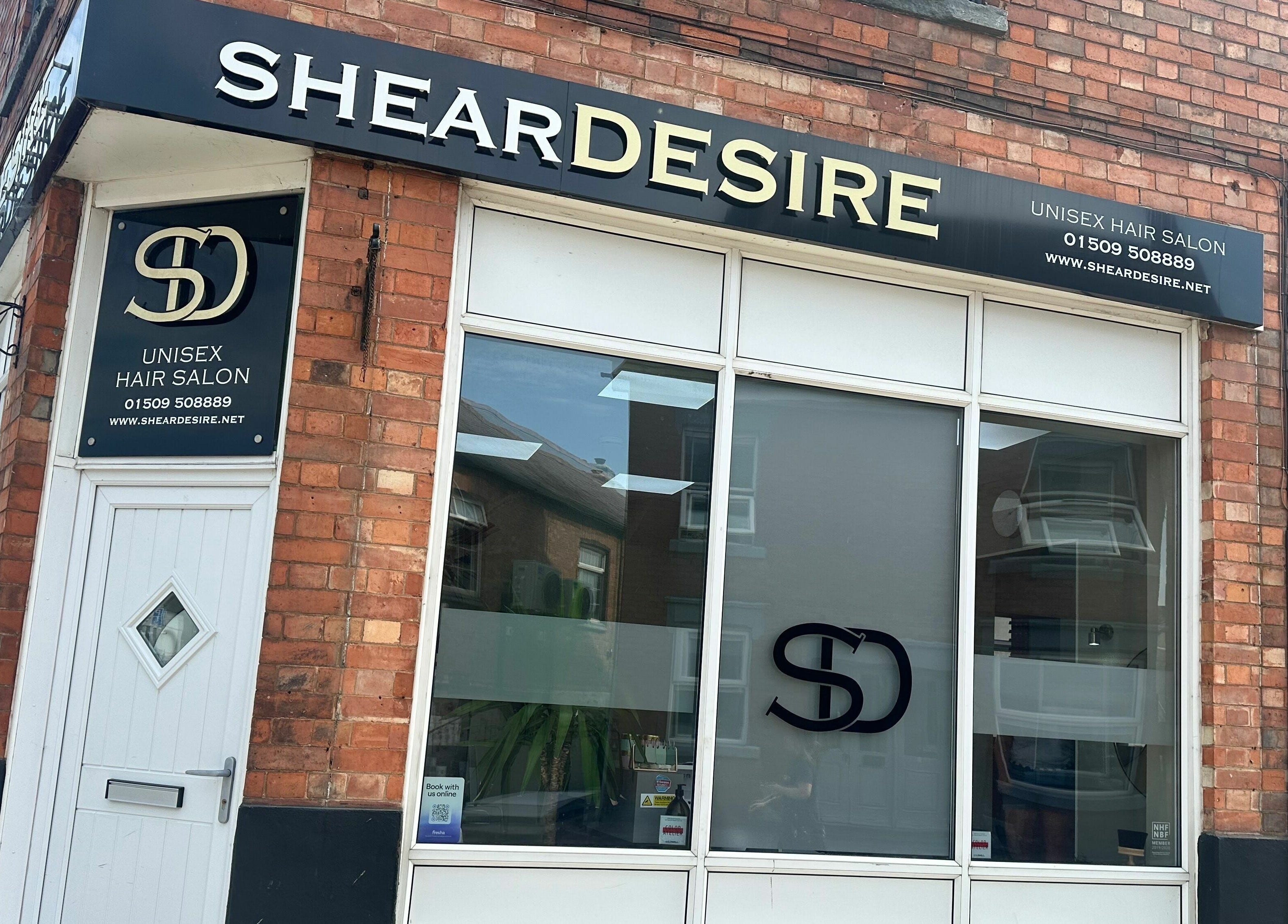 Front view of Shear Desire salon in Shepshed, England, GB with stylish glass windows and signage.