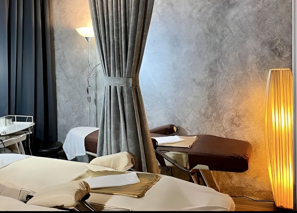 Tranquil treatment room at Puttharaksa Aesthetic in Bangkok, TH, featuring elegant decor and plush beds.