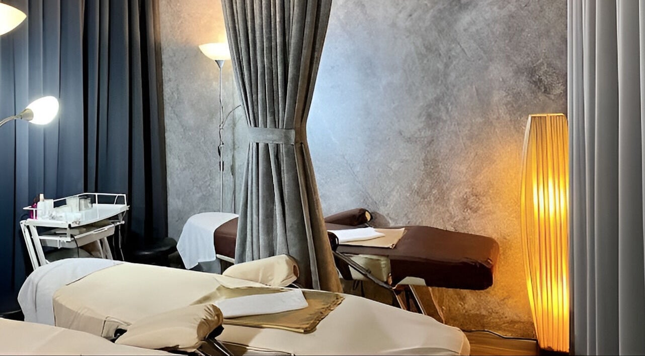 Tranquil treatment room at Puttharaksa Aesthetic in Bangkok, TH, featuring elegant decor and plush beds.