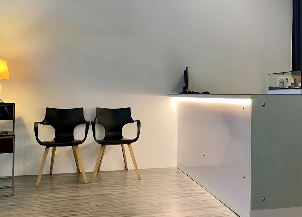 Modern reception area at Puttharaksa Aesthetic, Bangkok, TH with stylish chairs and elegant lighting.