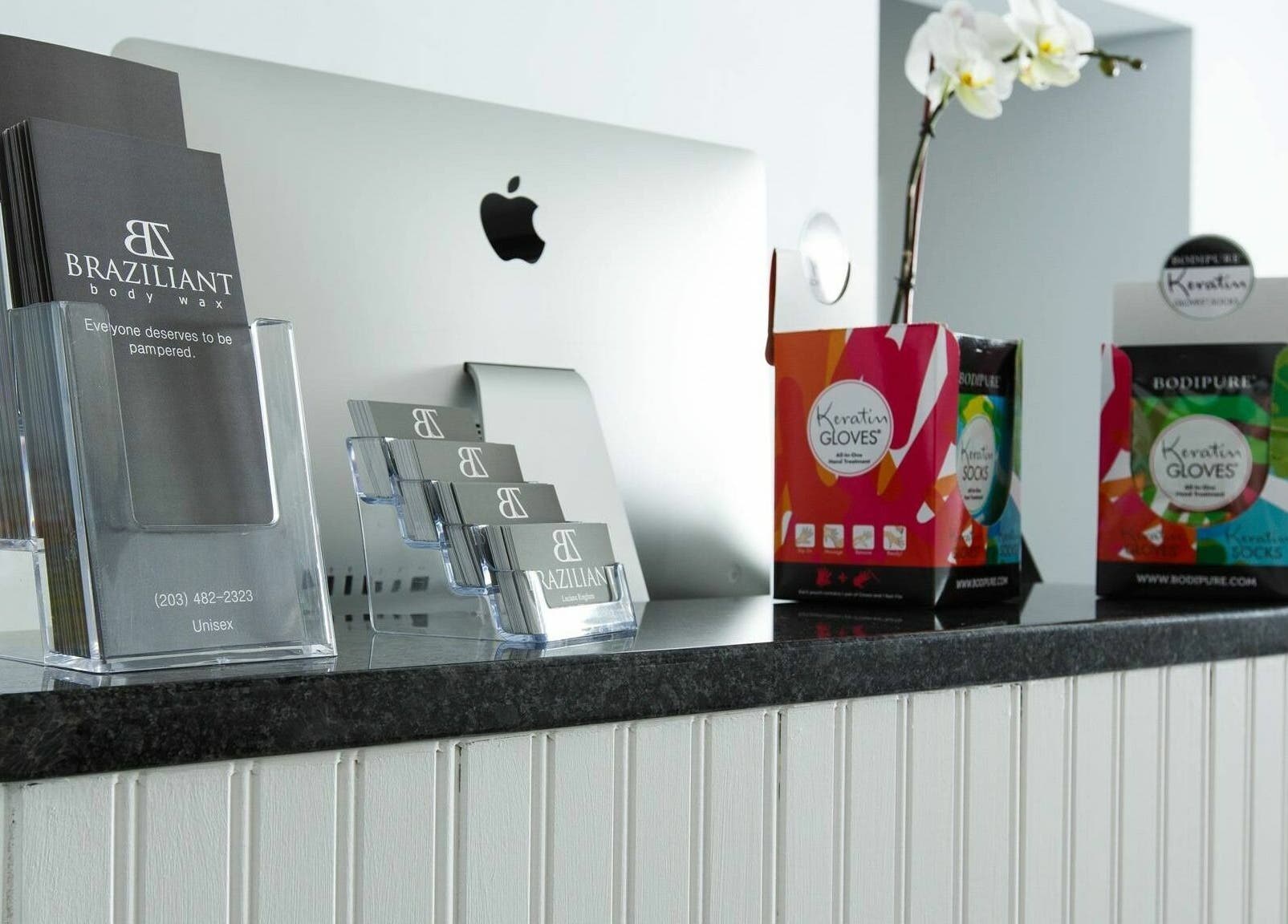 Reception desk at Braziliant Body Waxing in Ridgefield, Connecticut, showcasing brochures and beauty products.