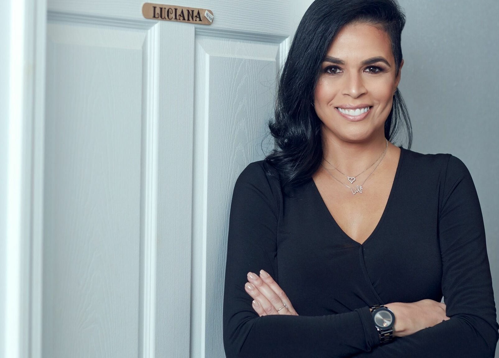Professional at Braziliant Body Waxing in Ridgefield, Connecticut, US, standing confidently by a treatment room door.
