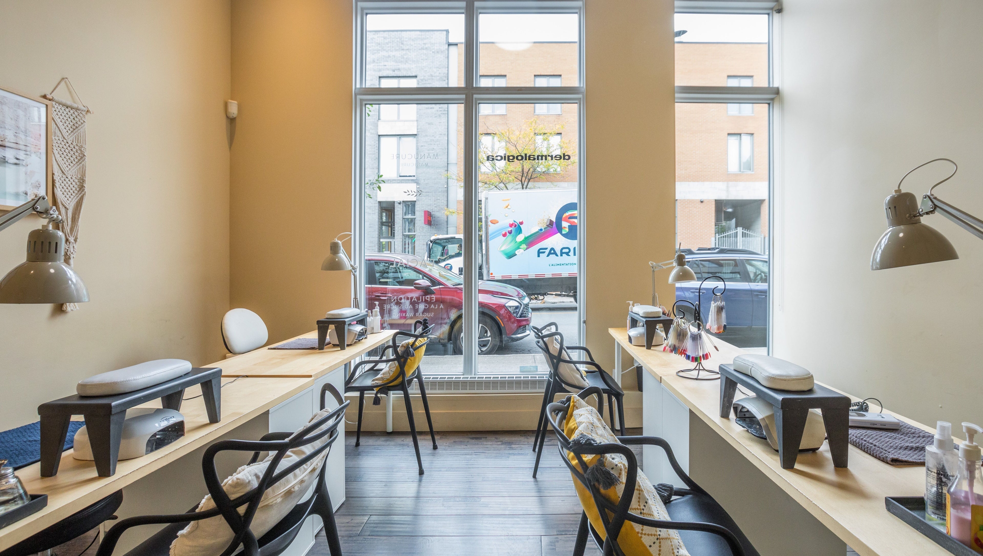 Modern nail service area at V and O Salon, Montréal, Québec, CA with stylish decor and large windows.