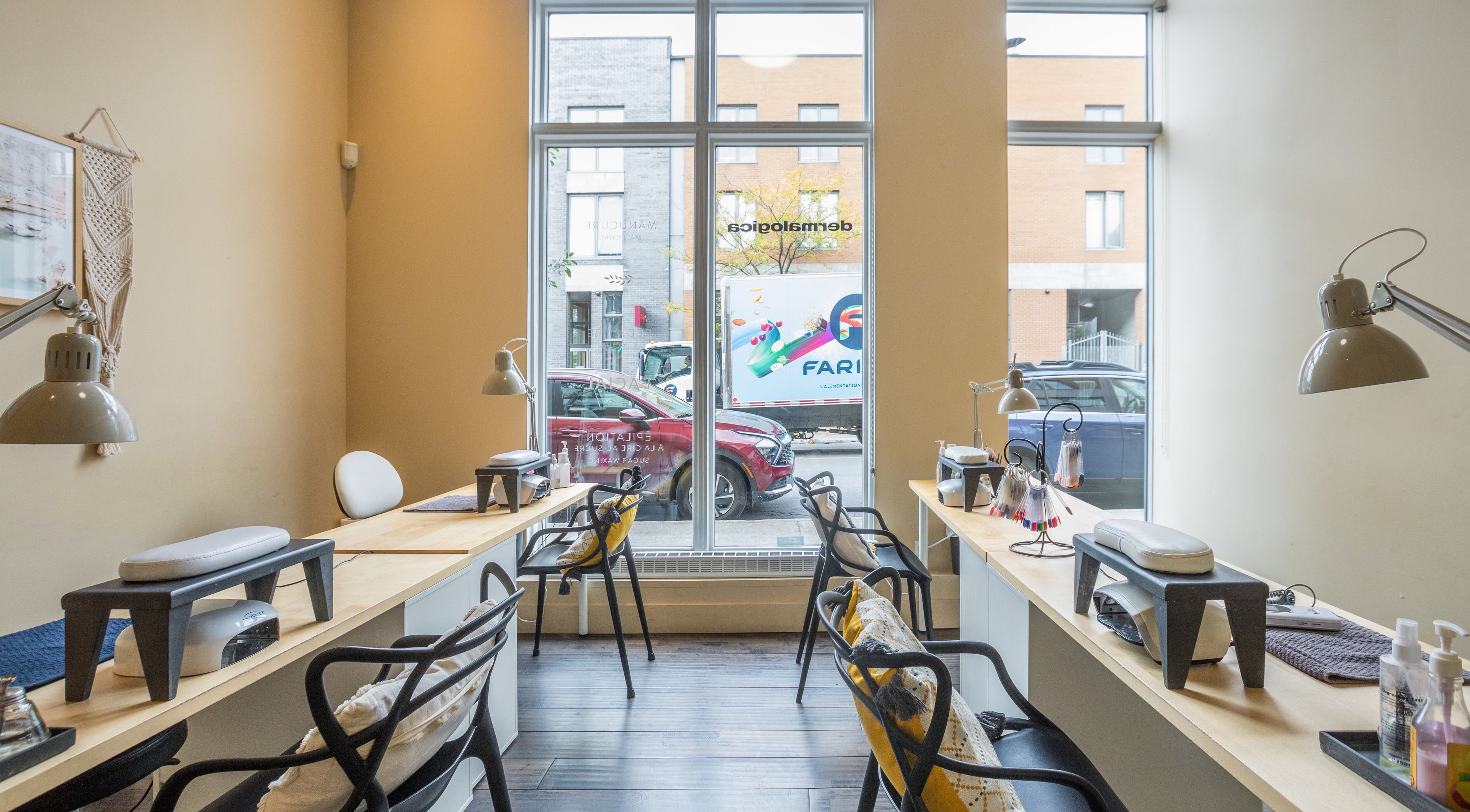 Modern nail service area at V and O Salon, Montréal, Québec, CA with stylish decor and large windows.