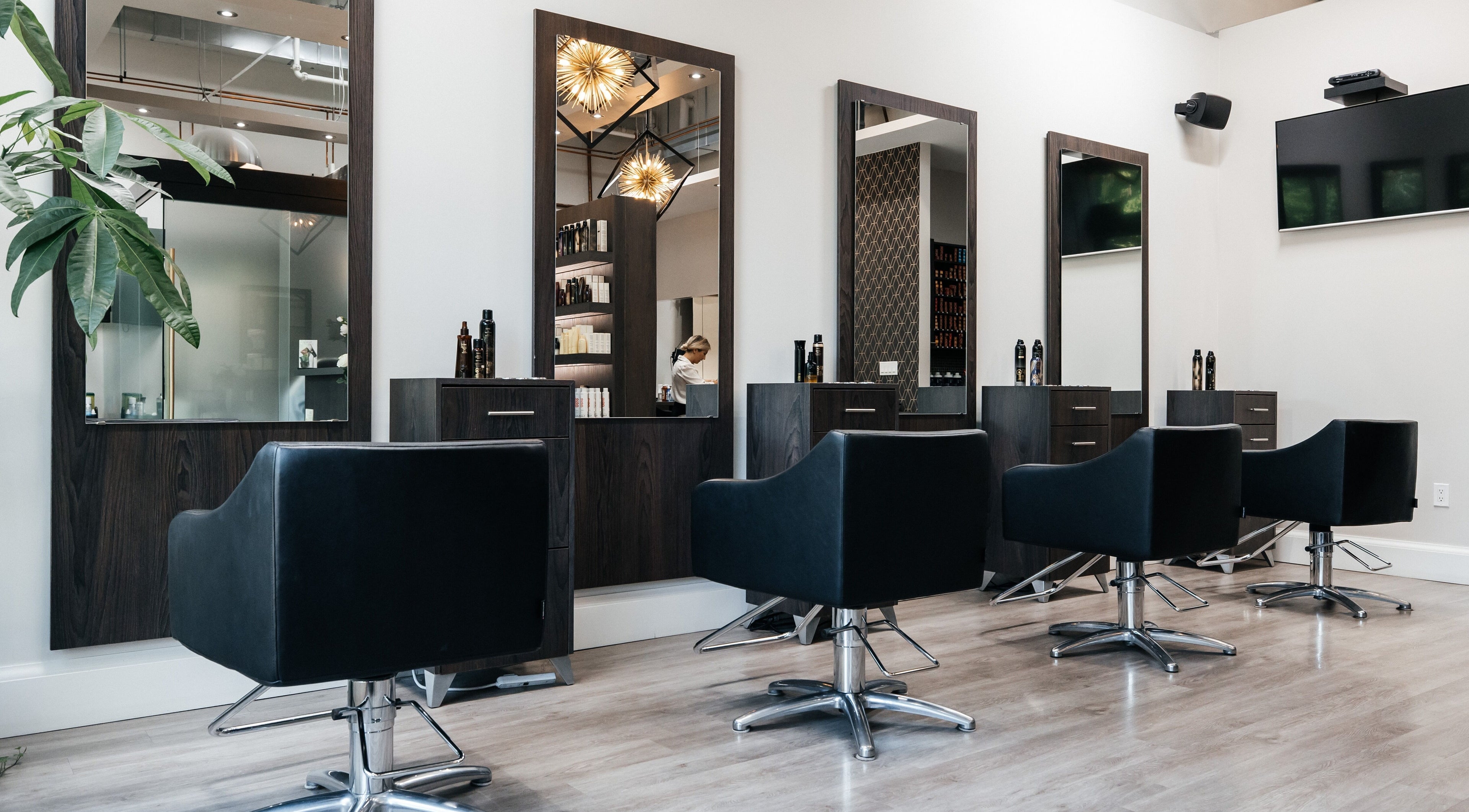 Modern styling stations at Scarlett O' Hair Beauty Salon, Toronto, Ontario, CA with elegant chairs and mirrors.
