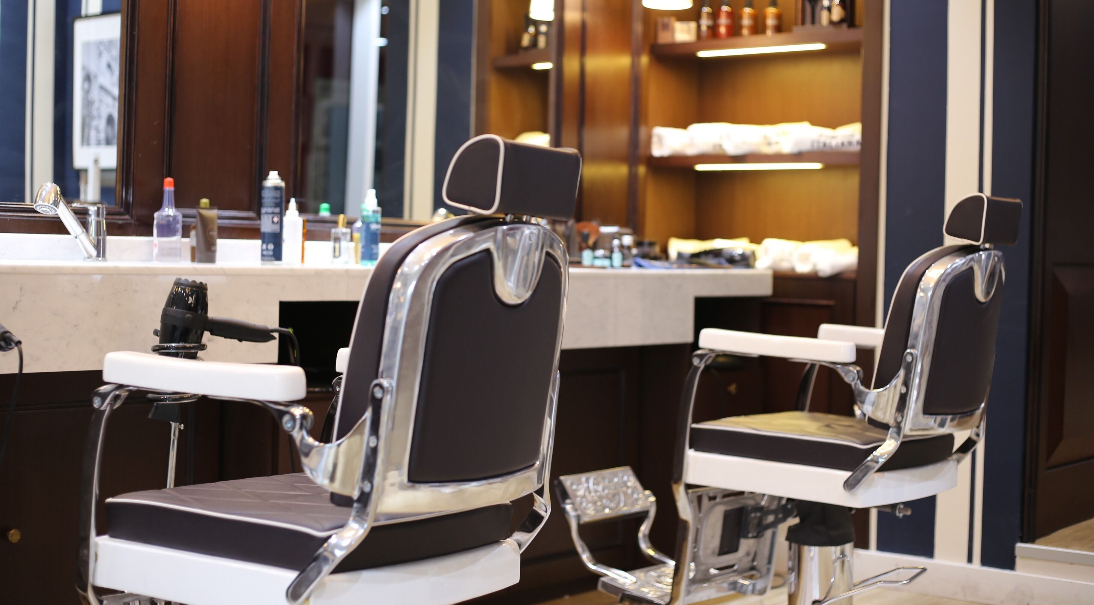 Elegant cutting station at Barberia Italiana - Dubai Marina, Dubai, AE featuring polished chairs and products.