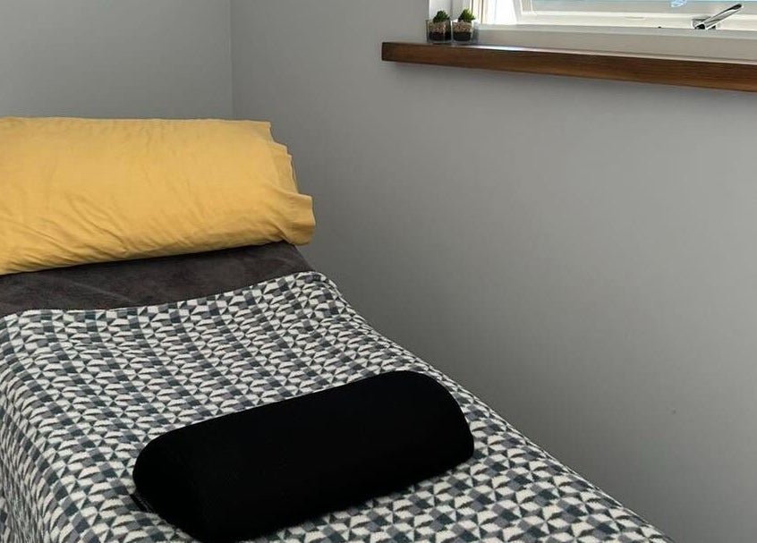 Cozy massage bed at Holistic Approach in Carrickfergus, Northern Ireland, GB, featuring a vibrant yellow pillow.