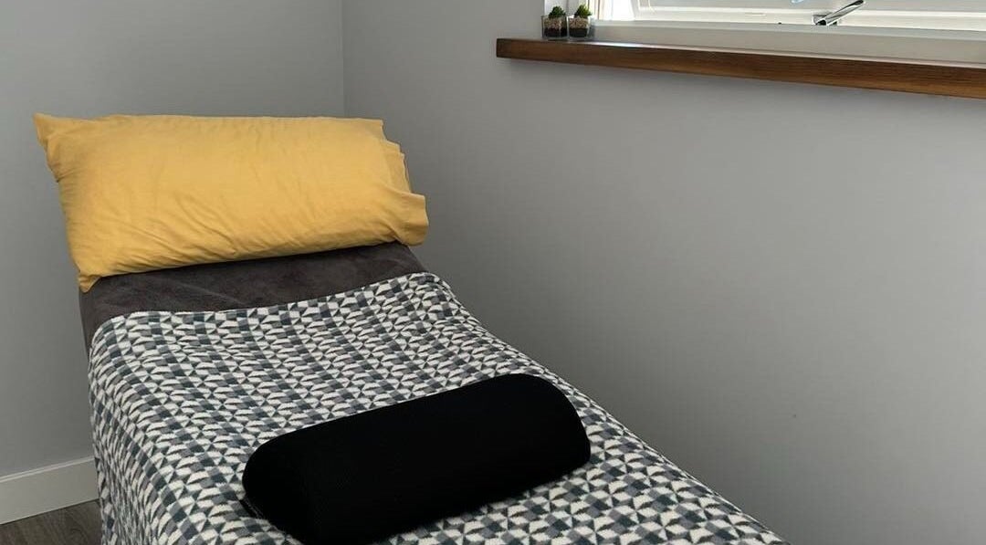 Cozy massage bed at Holistic Approach in Carrickfergus, Northern Ireland, GB, featuring a vibrant yellow pillow.