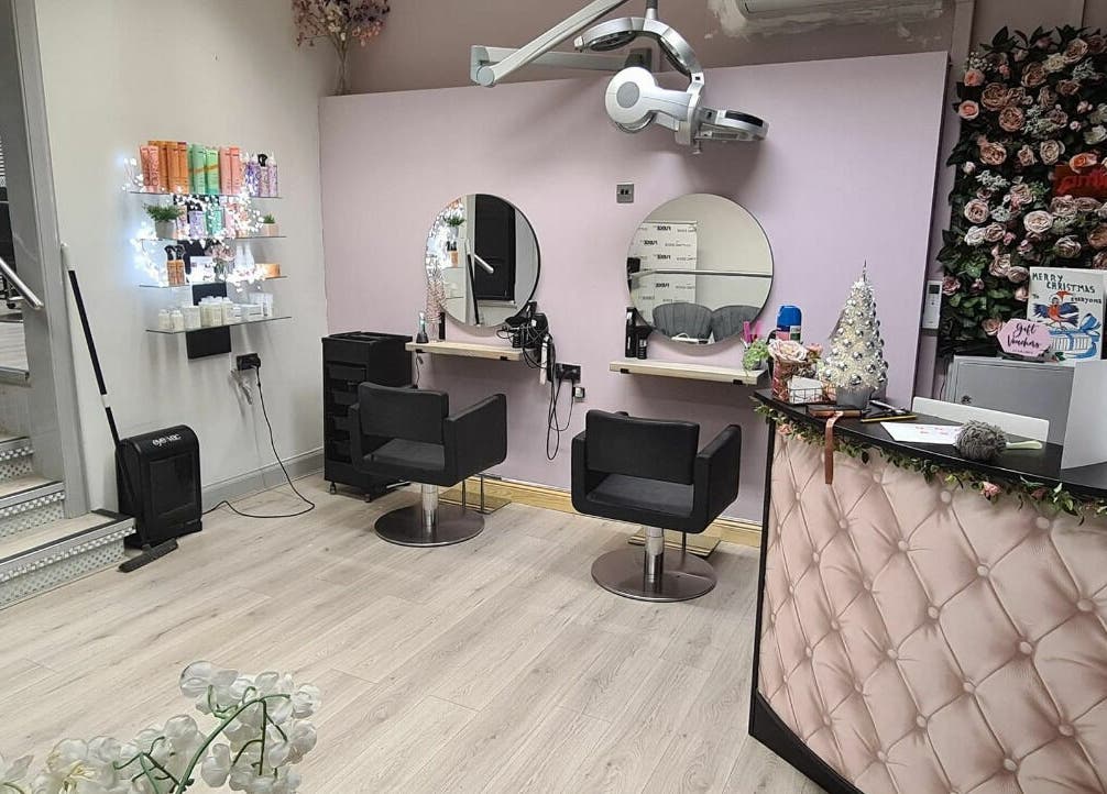 Elegant salon setup at The Cutting Edge, Dumfries, Scotland, GB. Features stylish chairs and a floral decor backdrop.