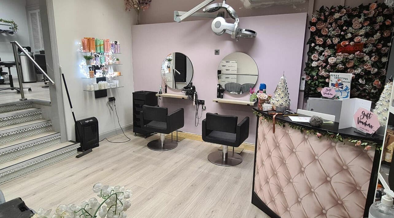 Elegant salon setup at The Cutting Edge, Dumfries, Scotland, GB. Features stylish chairs and a floral decor backdrop.