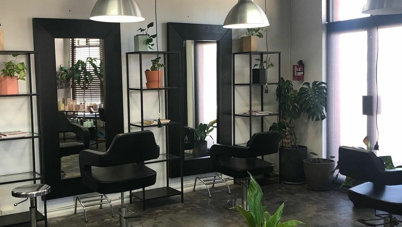 Modern hairdressing stations at Hairs on Fire in Fremantle, Western Australia, AU with sleek chairs and mirrors.