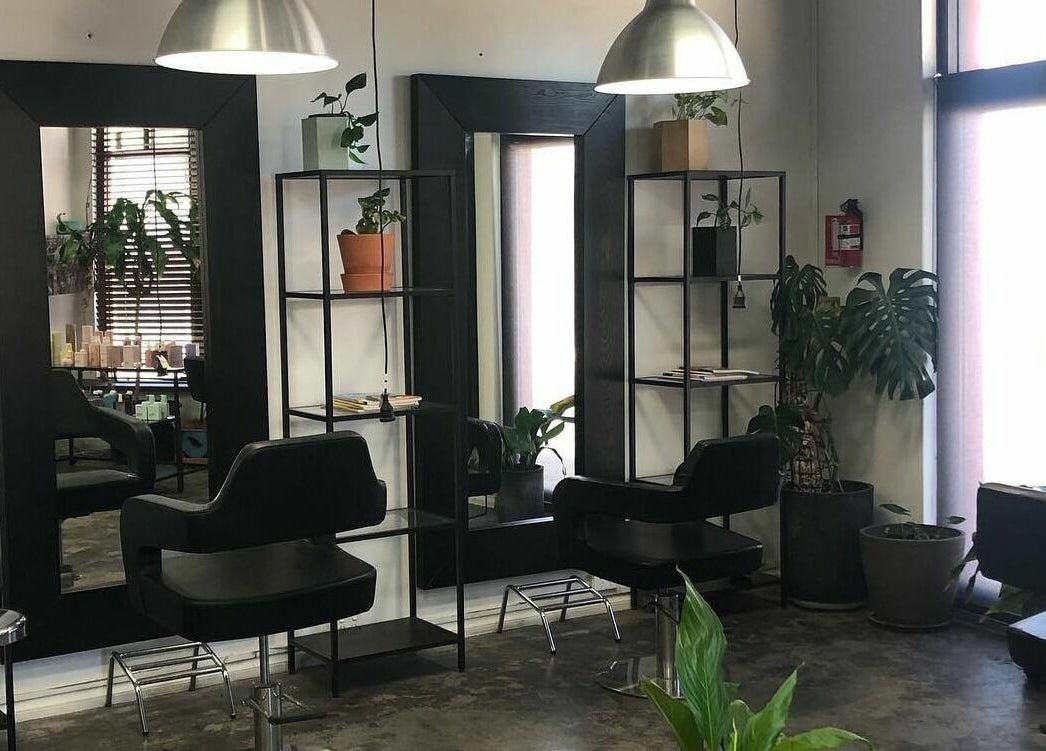 Modern hairdressing stations at Hairs on Fire in Fremantle, Western Australia, AU with sleek chairs and mirrors.