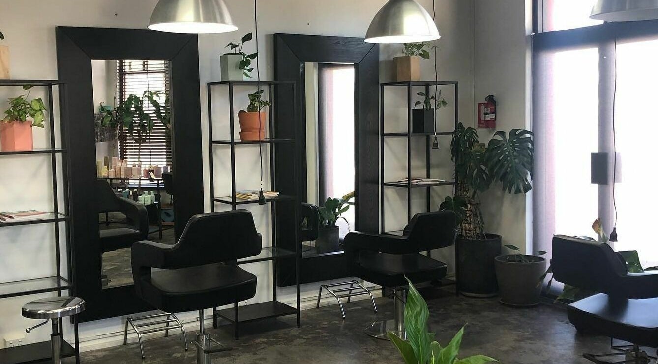 Modern hairdressing stations at Hairs on Fire in Fremantle, Western Australia, AU with sleek chairs and mirrors.