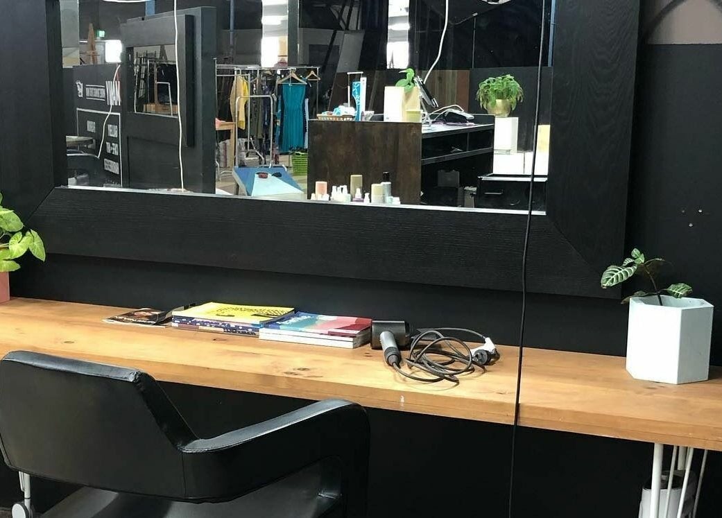 Modern styling station at Hairs on Fire, Fremantle, Western Australia, AU, featuring a sleek mirror and plants.