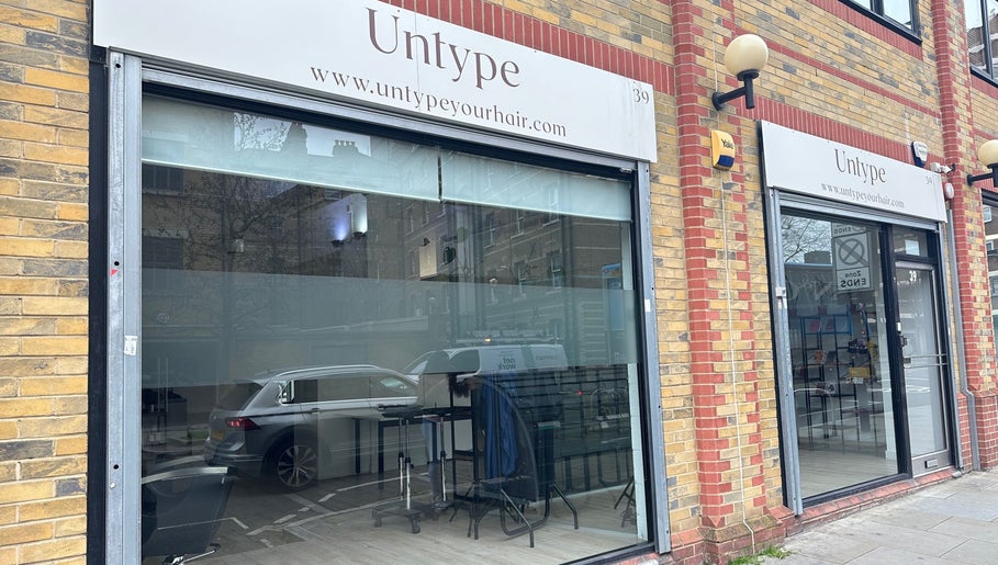Storefront of Zateesha Barbour, London, England, GB, featuring a modern glass facade with urban brickwork.