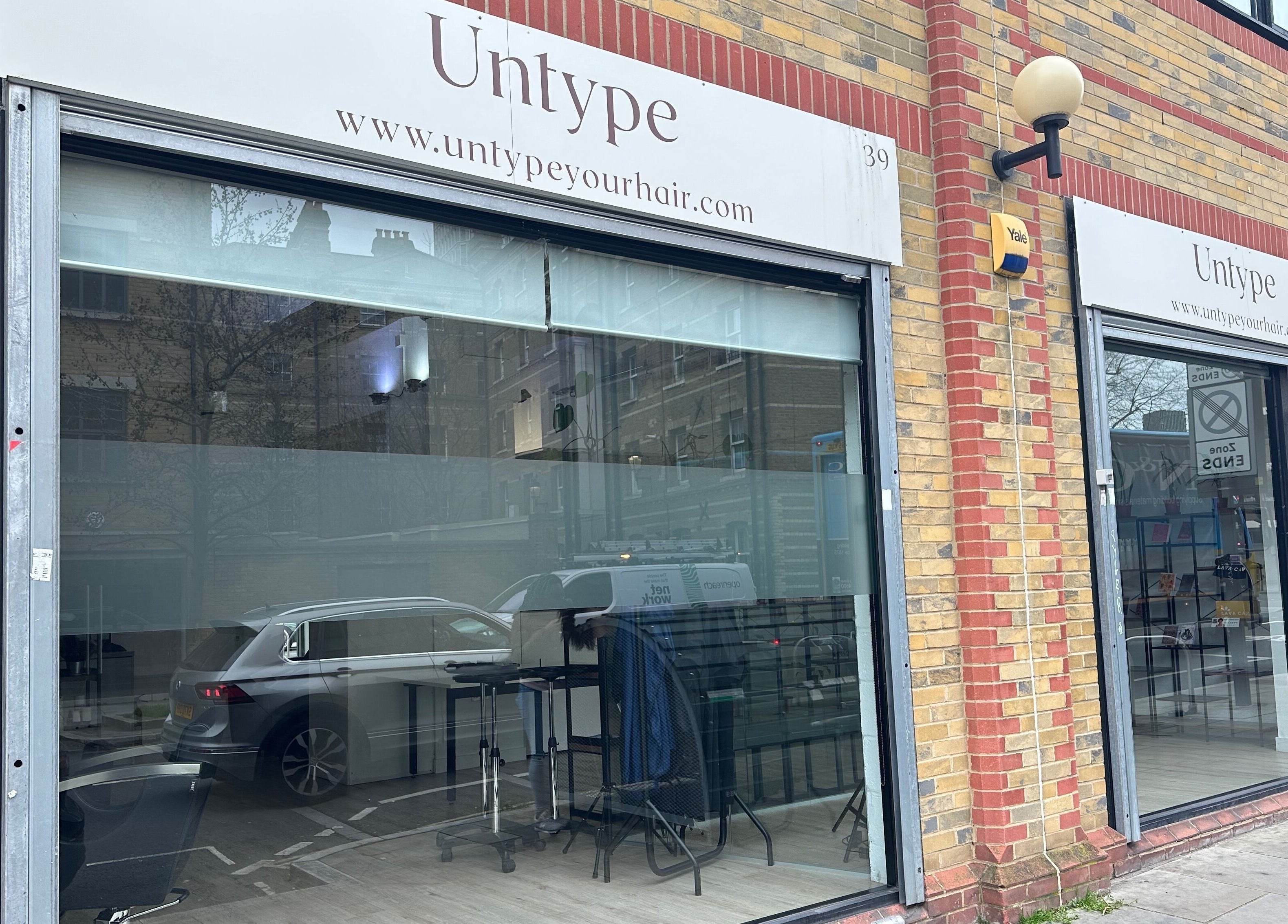 Exterior view of Zateesha Barbour salon in London, England, GB with stylish glass facade and modern signage.