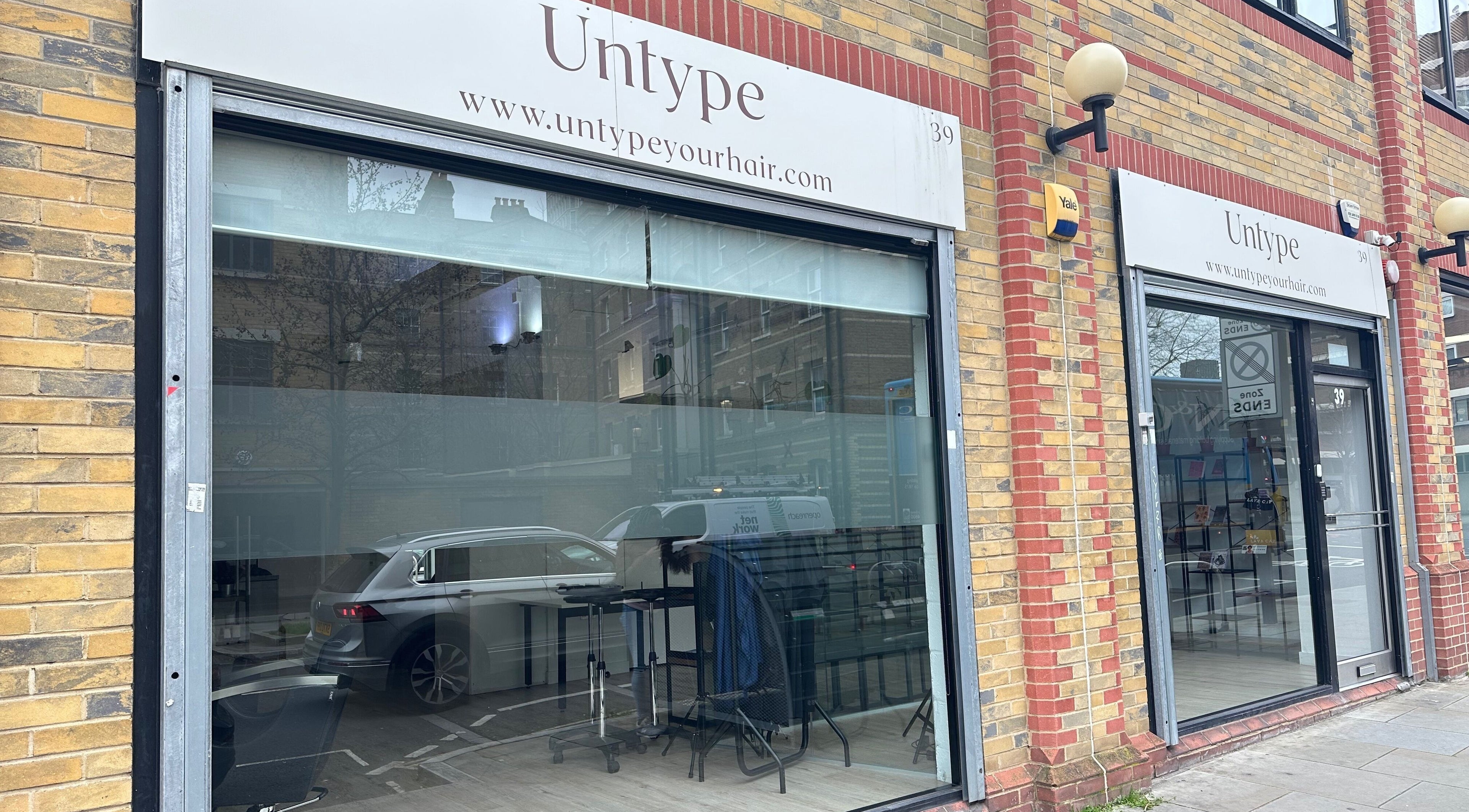 Exterior view of Zateesha Barbour salon in London, England, GB with stylish glass facade and modern signage.